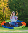 Child sitting on 40 Inch Kids Saucer Tree Swing Set With 600D Heavy Duty Oxford Fabric Platform Seat, Steel Frame And Carabiner Support