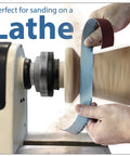 Emery cloth roll sandpaper on a woodturning lathe; blue abrasive belt wrapping a wooden piece (front view)