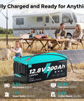 Beefy 12V 200Ah LiFePO4 Deep Cycle Battery powering RV setup outdoors with solar panels and family camping.