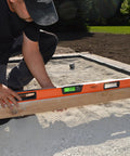 No Nonsense 48 Inch Digital Box Level Gives High Precision Readouts For Rock Straight Layouts used by a craftsman on gravel.