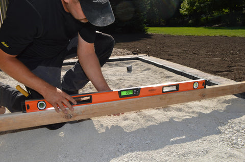 No Nonsense 48 Inch Digital Box Level Gives High Precision Readouts For Rock Straight Layouts used by a craftsman on gravel.