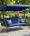 Outdoor Porch Swing With Stand And Canopy For Three Seats Adults Convertible 2 In 1 Swing Bed With Cup Holder Thick Cushions Heavy Duty Steel Frame 800 Lb Weight Capacity Built For Garden Yard Balcony Patio Blue shown in lush garden setting.