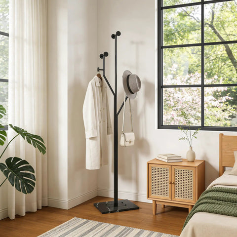 Heavy-Duty Freestanding Coat Rack With Tree-Shaped Metal Design And Marble Base in bedroom corner next to window.
