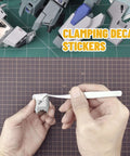 Hand using Ultra Precision Stainless Steel Tweezers Set With Two Pieces For Gundam And Scale Models to apply decal sticker