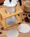 Hella Smooth Reusable Stainless Steel Coffee Filter Fine Mesh Compatible With AeroPress And Ultra Fine Brewers 51Mm displayed with coffee maker and mugs.