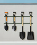 Various garden shovels on a wall, including Kids 28 Inch D Handle Shovel for Digging Gardening Beach and Camping Metal Blade With Fiberglass Handle.