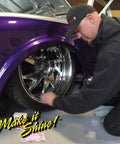 Man kneeling by a purple car, polishing a chrome alloy wheel with Wizards Metal Polish 3 oz.