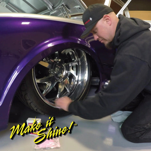 Man kneeling by a purple car, polishing a chrome alloy wheel with Wizards Metal Polish 3 oz.