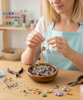 Woman making jewelry with 600 Piece Mixed Color Mini Screw Eye Pins For Jewelry Making And DIY Crafts, tools and beads on table.