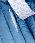 Close-up of Tenacious Tape 3 Inch By 20 Inch Nylon Fabric Repair Tape Patch for holes in a blue jacket