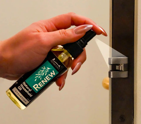 Hand applying Renew Natural Household Oil Unscented All Purpose Lubricant Spray For Doors Hinges And Locks Eco Conscious to a door hinge