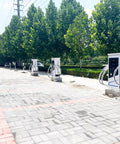 Heavy Duty Level 3 EVSE Charging Station With High Current Floor Pedestal Build Rock Solid DC Fast Charger in a charging area with green trees.