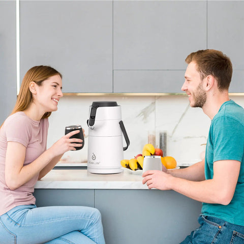Couple enjoying drinks with Thermal Coffee Carafe 74oz Stainless Steel Vacuum Insulated Water Jug For Hot Or Cold Beverages on counter