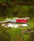 Kids Pocket Knife Toy 4.4 Inch VX Red Swiss Army Style Pretend Tool on a mossy wooden stump, safe play option for young adventurers.