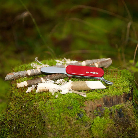 Kids Pocket Knife Toy 4.4 Inch VX Red Swiss Army Style Pretend Tool on a mossy wooden stump, safe play option for young adventurers.
