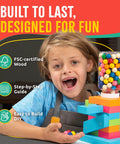 Child with assembled Candy Dispenser Woodworking Kit For Kids A Hands On STEM Building Project With FSC Certified Wood Paints And Tools.