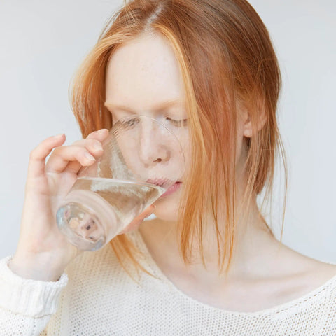 Person drinking water filtered by 3 Pack Water Filter Replacement For Pitchers And Dispensers 4 In 1 Filtration System Cuts Chlorine PFOA PFOS