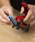Hands loading staples into Heavy Duty Cable Boss Staple Gun Pro Grade For NM Coax And Low Voltage Wiring Ergonomic Handle Front Grip