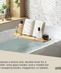 Aquala Extendable Bathtub Tray Caddy With Book Stand And Wine Glass Holder Phone Stand in use on a tub with book and drink.