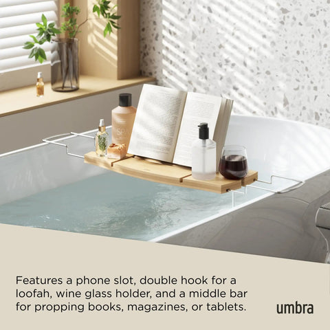 Aquala Extendable Bathtub Tray Caddy With Book Stand And Wine Glass Holder Phone Stand in use on a tub with book and drink.