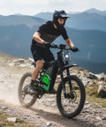 Adult riding Heavy Duty Adult Electric Dirt Bike With Full Suspension Fat Tires And Hydraulic Brakes on rocky trail.