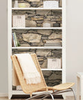 Bookshelf with Hadrian Stone Peel And Stick Wall Covering Brown Removable Wallpaper on shelves, showcasing stone texture effect.