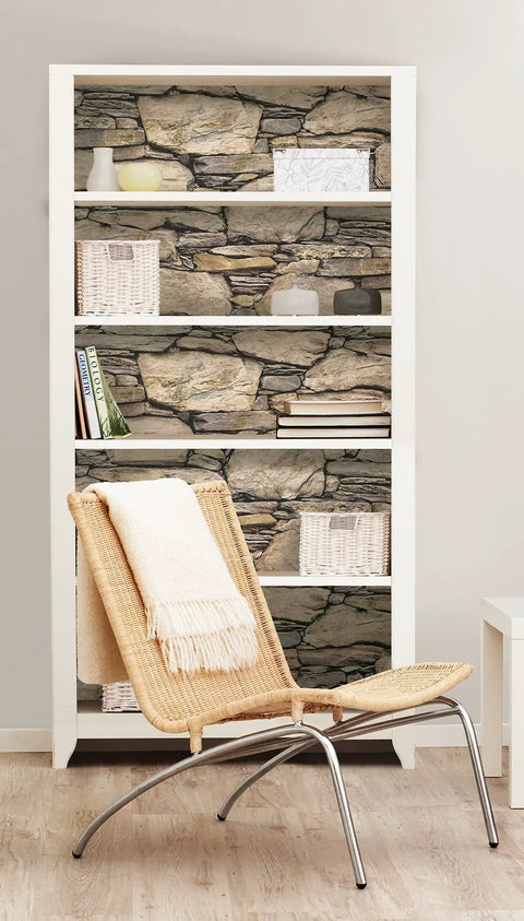 Bookshelf with Hadrian Stone Peel And Stick Wall Covering Brown Removable Wallpaper on shelves, showcasing stone texture effect.
