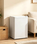 3 Cu Ft Compact Upright Freezer With Reversible Door And Bright White Shell in living room corner next to a sofa.
