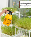 Person using a spray bottle on a Vertical Hydroponic Garden Tower With Wheels And Metal Shelf All In One Sprouts Growing Kit