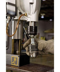 DEWALT magnetic drill press, 2-inch capacity, 10-amp motor, 2-speed; front view with chuck and gloved hand.