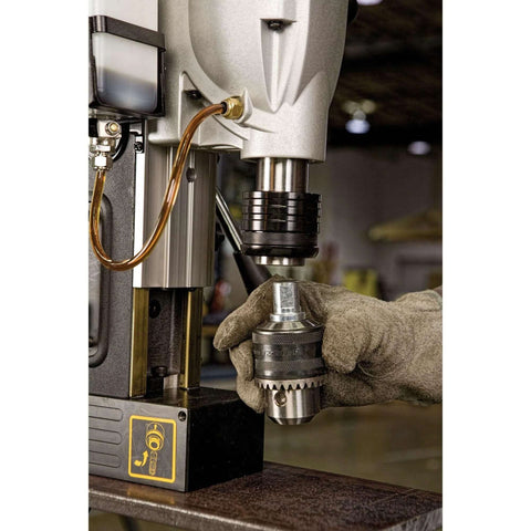 DEWALT magnetic drill press, 2-inch capacity, 10-amp motor, 2-speed; front view with chuck and gloved hand.