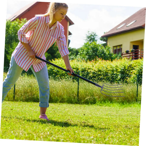 Person using Versatile Handheld Manure Fork For Lawn Garden And Farm Use Five Prong Pitch Fork With Durable Long Lasting Build outdoors