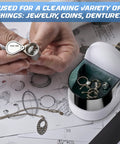 Cordless Jewelry And Denture Cleaner for rings, coins, and dentures, with hands holding a small metal piece over the unit