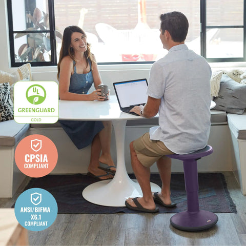 Woman sitting at a table with a man on SitWell Wobble Stool With Adjustable Height For Active Seating And Core Engagement, Eggplant Purple