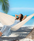 Woman relaxing in Garden Cotton Hammock With Spreader Bar For Patio And Backyard Ultra Comfortable And Strong Up To 450 Lbs