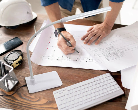 Uno LED Art And Craft Table Lamp with Independent Switch illuminating a workspace with architectural plans and tools