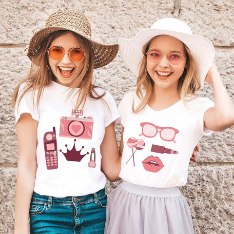 Two women wearing decorated shirts using Gradient Pink Heat Transfer Vinyl Pack With 12 Sheets For DIY Clothing And Costume Crafting.