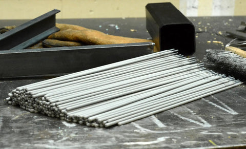 5 64th Inch E6013 Arc Welding Electrodes, 5 Pound Pack, All Purpose Welding Rods For Mild Steel, Easy To Start At Low Amps, Works In All Positions, 60,000 PSI Weld Strength, Best On Clean Light Gauge Metal, Great For Beginners To Pros. Stack of 5/64 inch E6013 rods on a workbench