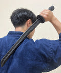 Man practicing with Polypropylene Short Practice Samurai Training Sword 24-Inch With Black Saya Scabbard, holding sword overhead.