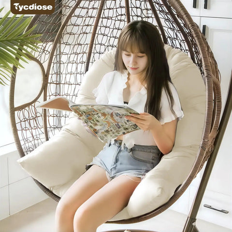 Waterproof Outdoor Egg Chair Cushion Replacement For Hanging Egg Chairs 47x33x7 Inches U Shaped Thick Pad Cream Mega Comfy Water Resistant Pad For Hammock Swing Chairs in a hanging egg chair with a person seated, reading.