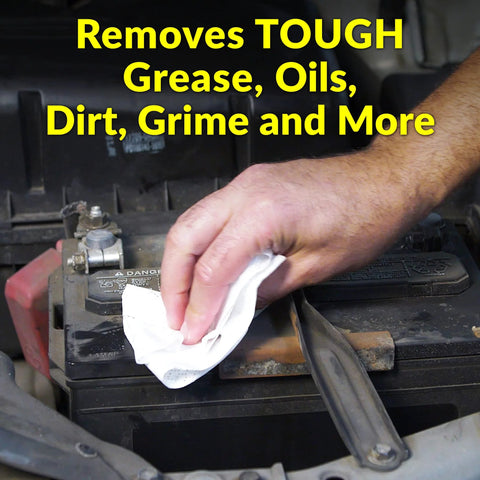 White heavy-duty cleaning towel used to wipe car battery terminals (hand close-up)