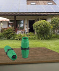Ultimate Expandable Garden Hose Repair Kit With Dual Channel Quick Connectors For 25 50 75 100 FT Lines. green plastic hose mender pieces on wood table