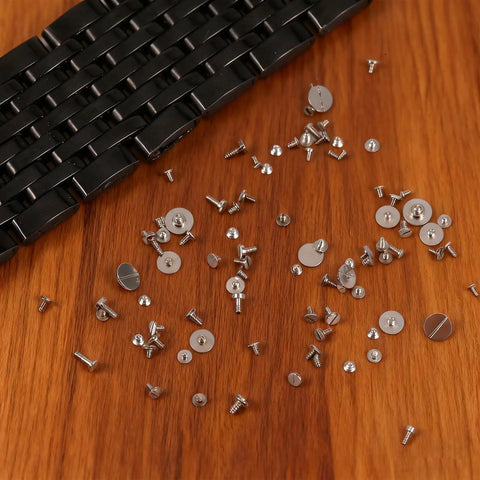 100 Piece Watch Screw Set With Micro Battery Clamp Screws, Stainless Steel Assortment for watchmaking and repair on wooden surface