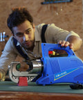 Heavy Hitter 15 Ton Electric Hydraulic Cable Lug Crimping Tool with blue casing and crimping head on a workbench.