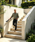 Man using Heavy Duty Flush Wall Mount Stair Railing In Corrosion Resistant Stainless Steel With Matte Black Finish Six Foot Length on stairs.