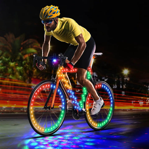 Cyclist at night with Disco Bike LED Light Kit 4 Pack With 2 Wheel Lights, 1 Frame Light, 1 Headlight Battery Powered Color Changing Neon Glow