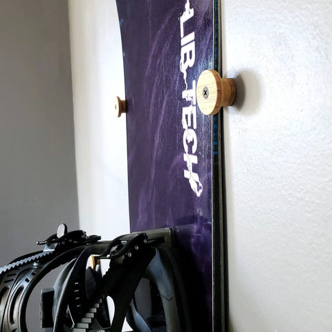 Bamboo flush ski wall mount holding a snowboard flat against the wall, demonstrating Keep Your Winter Setup Clean With These Sick Bamboo Flush Ski Wall Mount And Snowboard Rack Solutions Solid Space Saving Storage That Holds Boards Flat Against The Wall While You Rip.