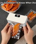 Hands using Rechargeable Mini Bag Sealer With LED Power Display One Touch Heat Sealer And Cutter Six Adjustable Gear Settings Portable Resealer For Chips Snacks And Mylar Bags USB C Charge On The Go with dried fruit bag.