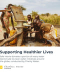 Children collecting water from a pump in a rural area with text about Safe Home donating to Charity Water initiatives.