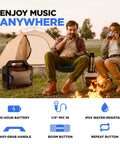 Tailgater Boom Outdoor Portable Bluetooth Speaker With Mic In FM Radio USB Port Battery IPX5 Water Resistant Wireless Stereo Link App Control 60W Peak Power next to tent and people enjoying campfire